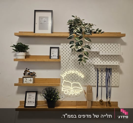 מדפי עץ צפים ולוח מחורר מותקנים ומעוצבים על קיר לבן